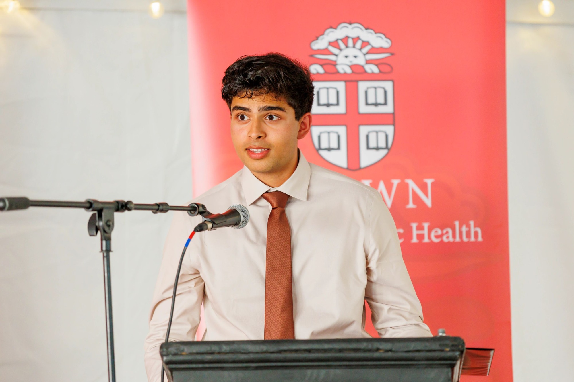 man addresses audience from podium