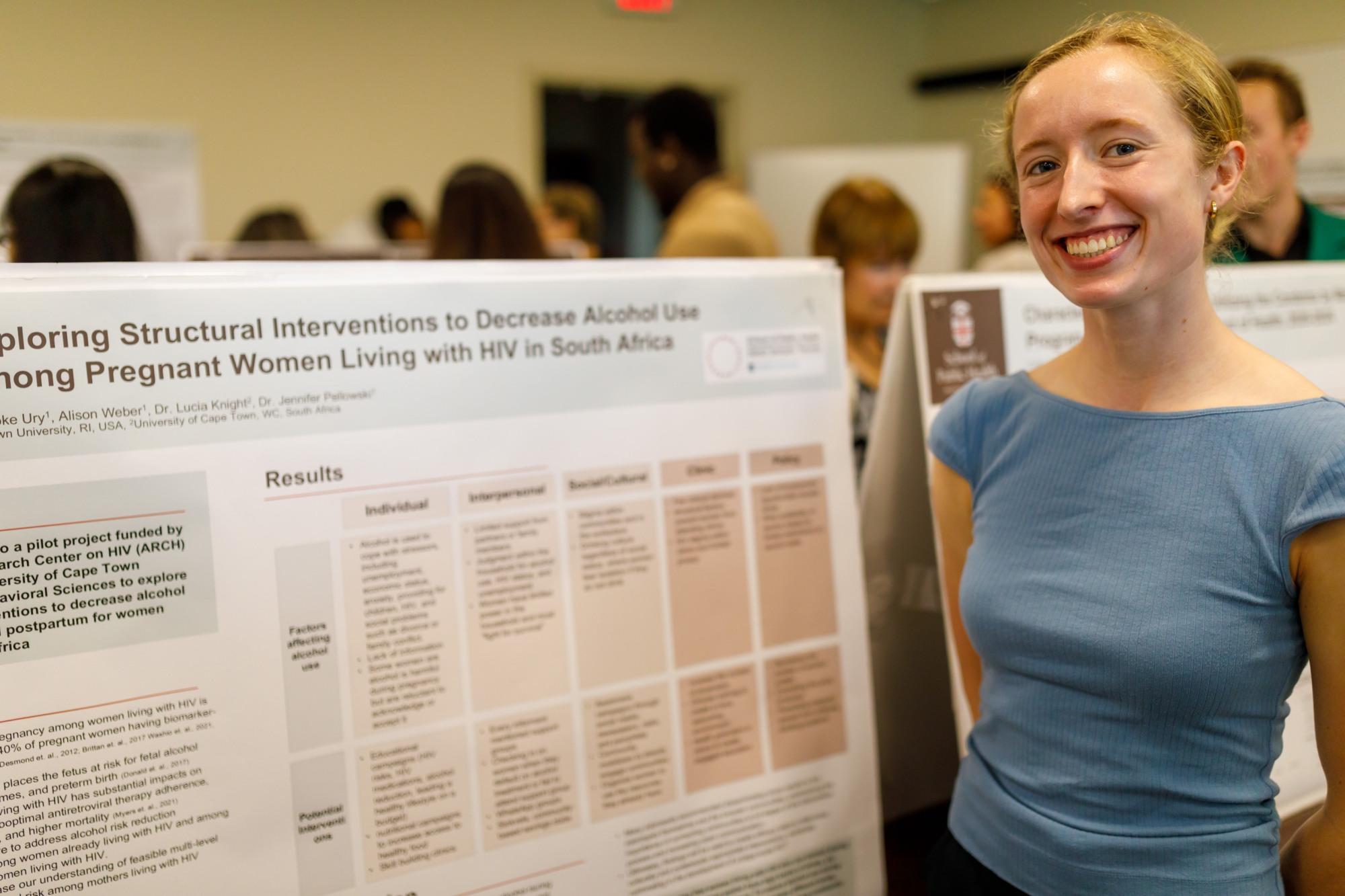 woman smiling next to scientific poster