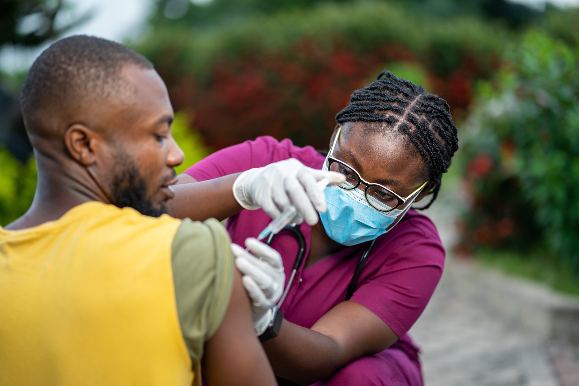 Female nurse administers a vaccine to a man