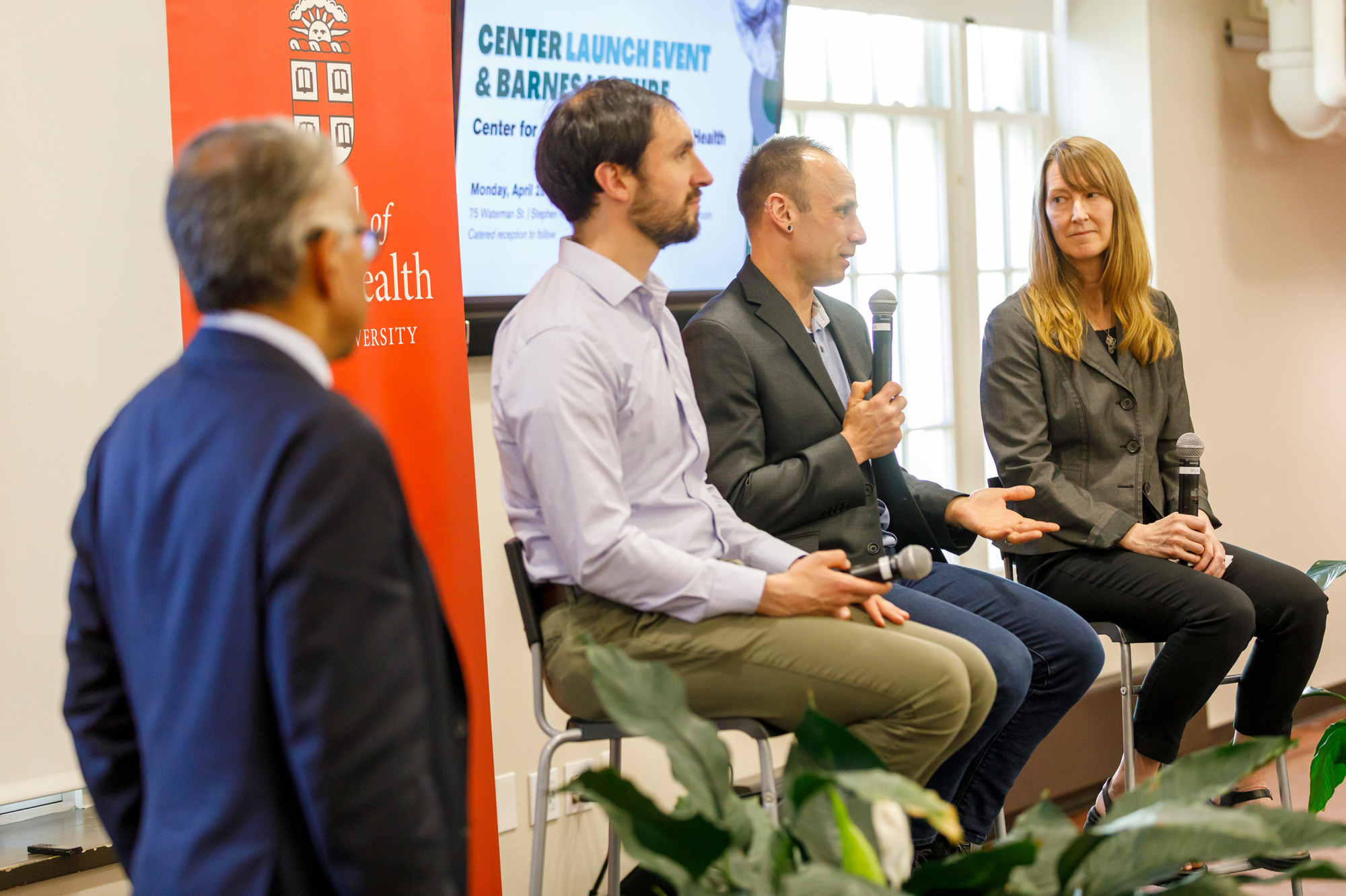 three academics speaking on a stage