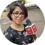 Laura Garcia holds a microphone on the street