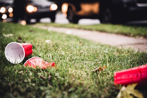 crushed and emptied red drinking cups on lawn