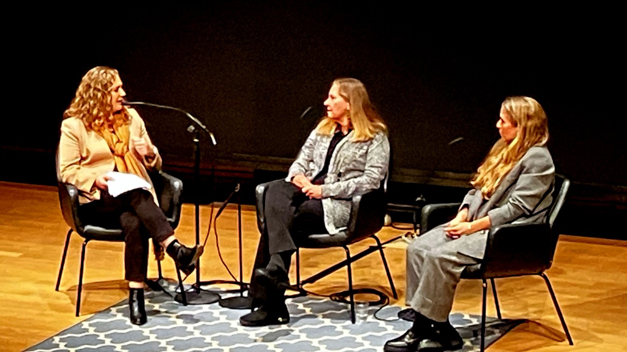 three women onstage, talking