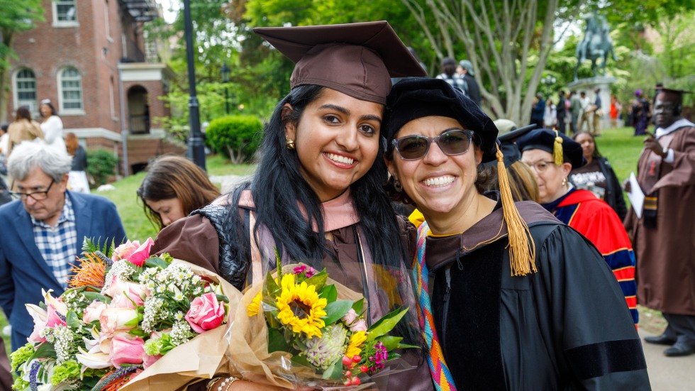 Graduate posing with a professor