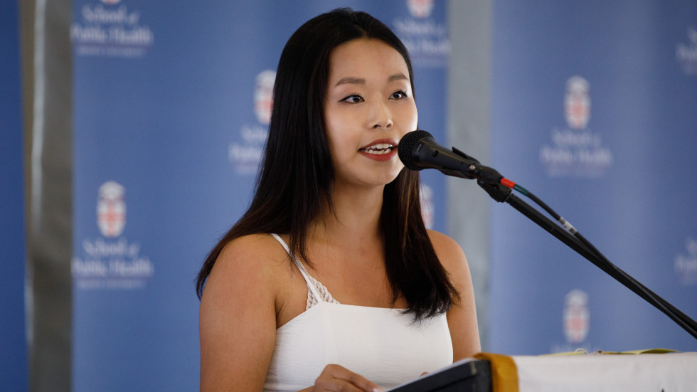 Kate Choi ’26 speaks to the audience at the microphone.