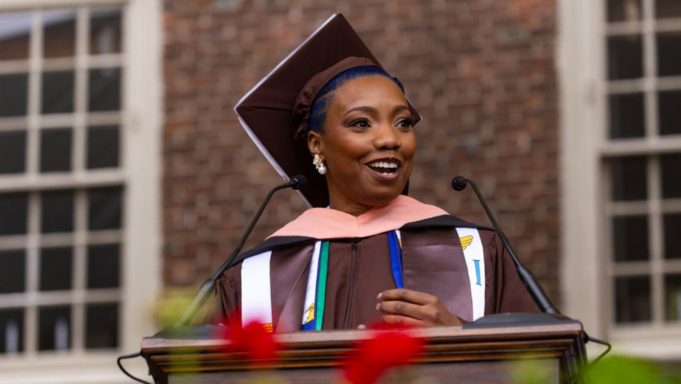Kenia Collins, wearing Brown regalia, delivers the Master’s student address at the Brown Master’s Ceremony.